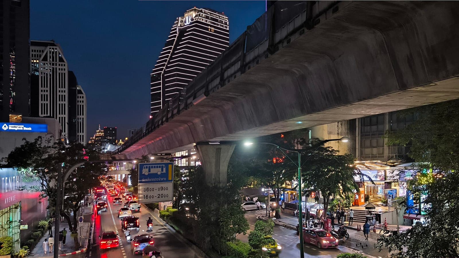 Sukhumvit Road, Bangkok, at dusk with the BTS viaduct, traffic and lit towers