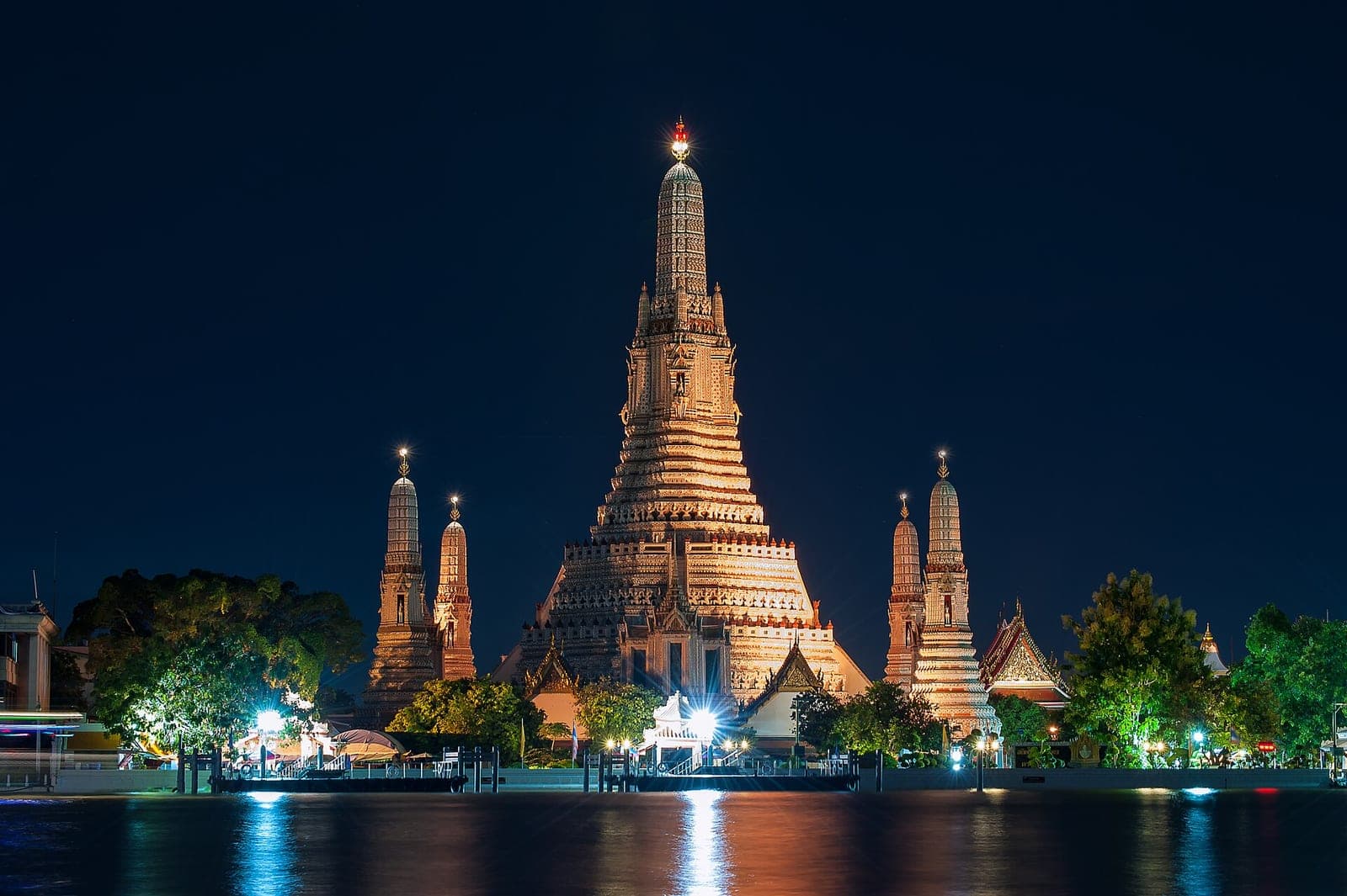 Wat Arun in Bangkok lit up at night and reflected in the Chao Phraya River
