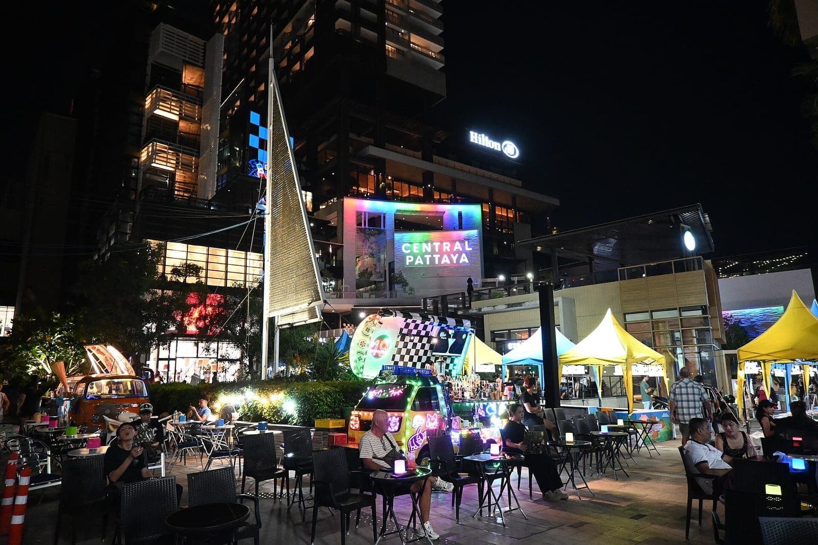 Outdoor dining plaza with food stalls in front of Central Pattaya mall at night