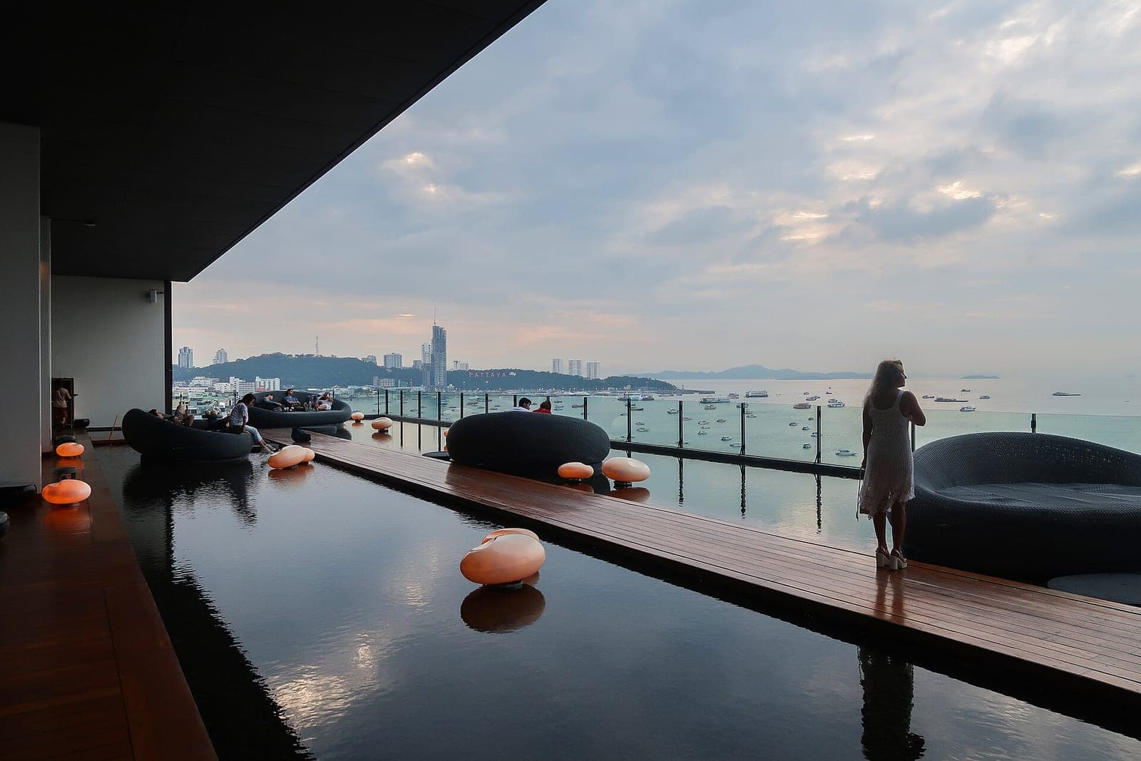Rooftop pool deck of the Hilton Pattaya at dusk overlooking Pattaya Bay