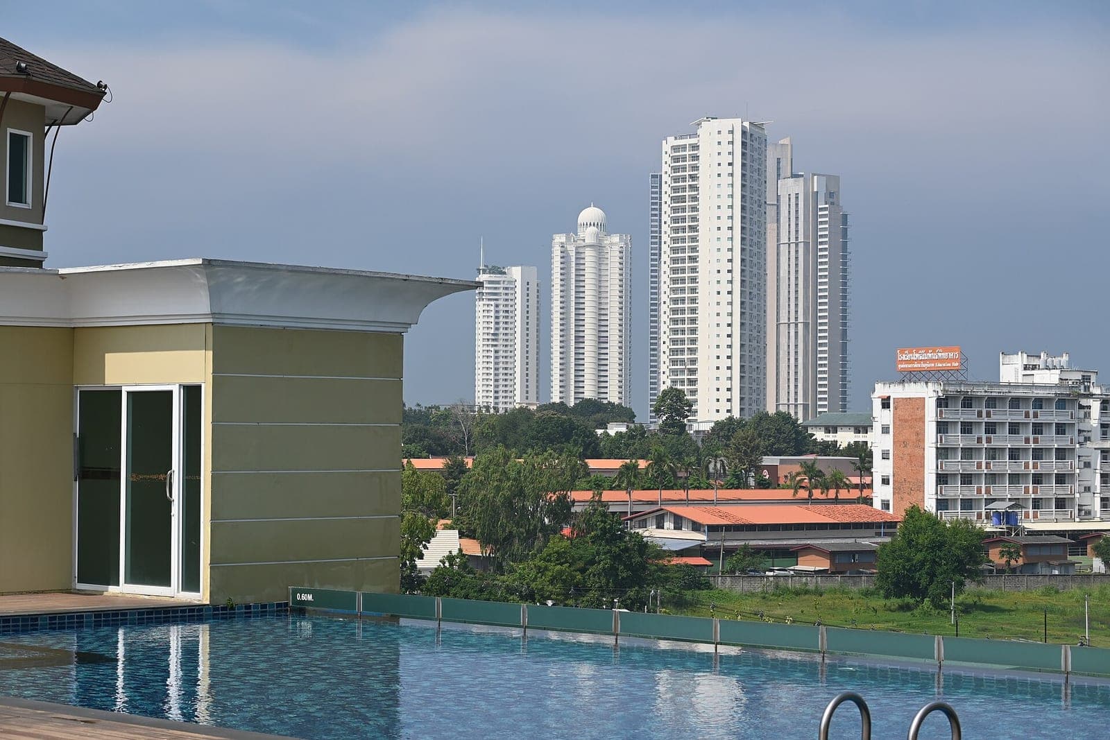 Rooftop infinity pool in Pattaya overlooking high-rise condominium towers