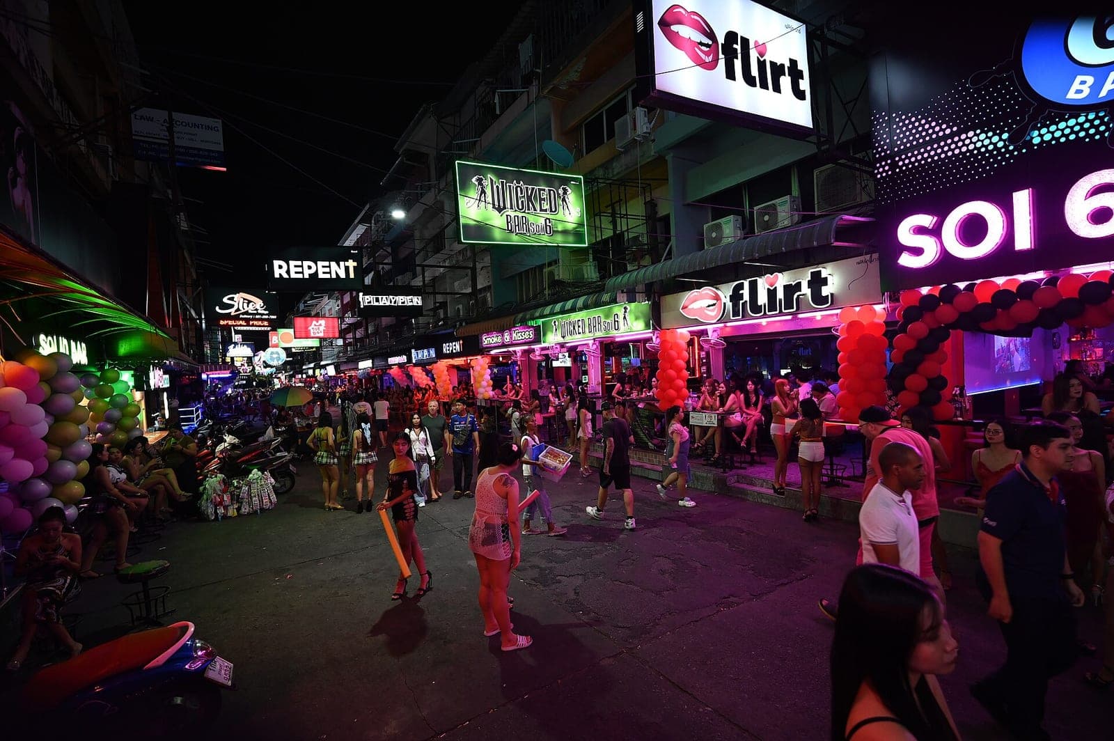 Soi 6, Pattaya, at night with bar signs, neon and bar staff outside the venues