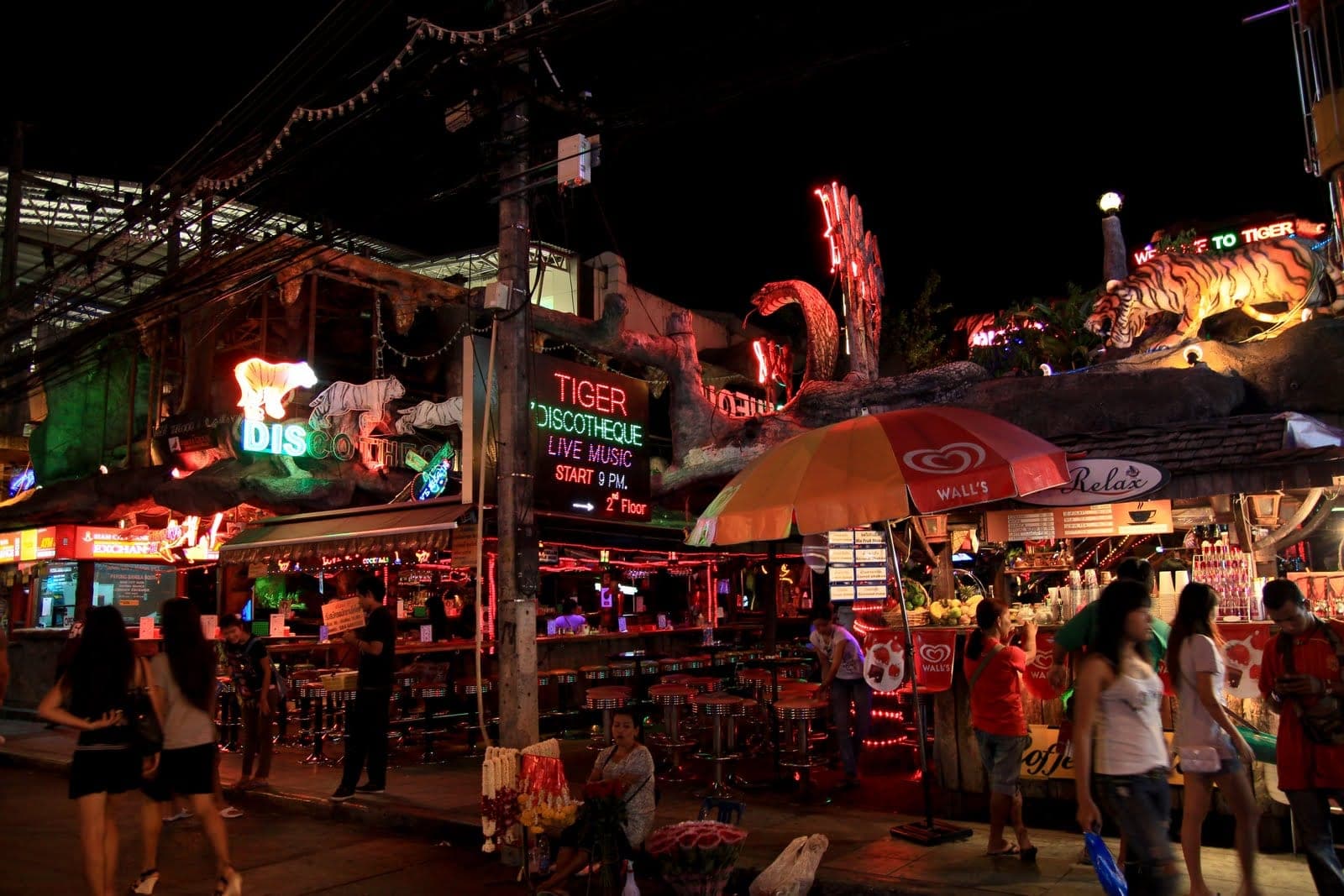 Open-air bars and the Tiger Disco frontage on Bangla Road, Patong, at night with bar staff and tourists
