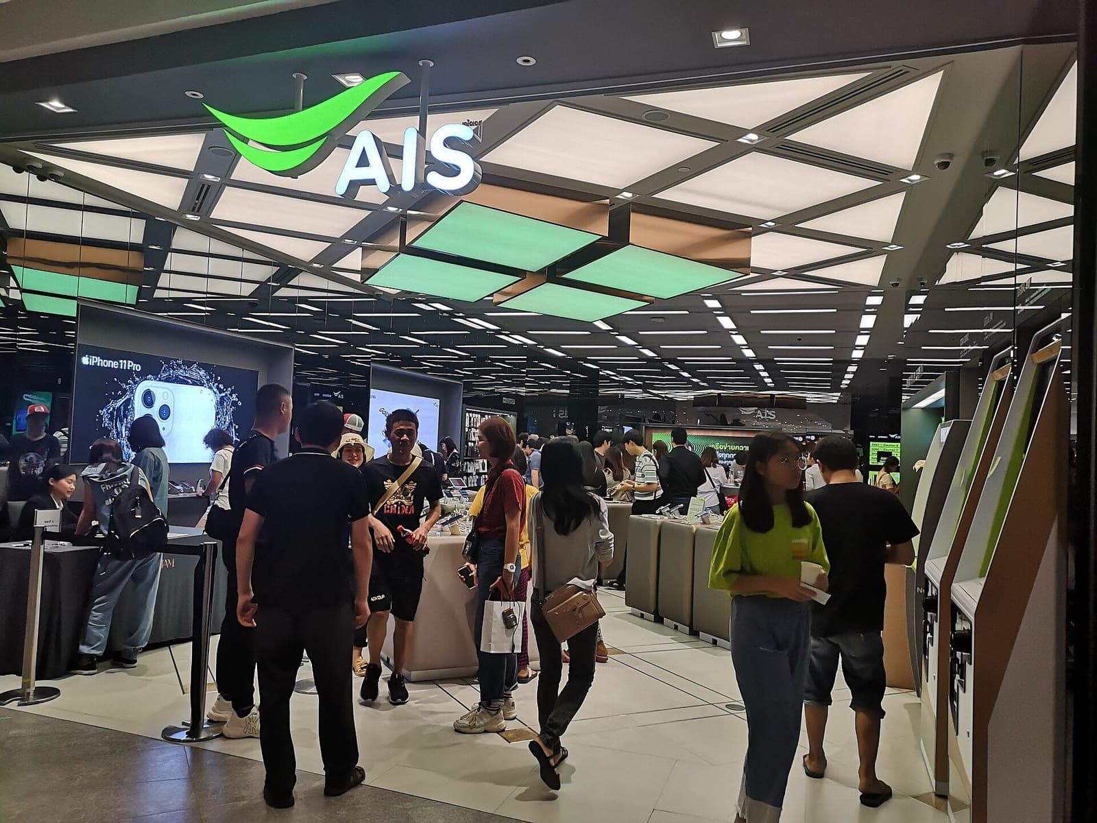 AIS mobile operator shop inside a Bangkok shopping mall with customers at the counter