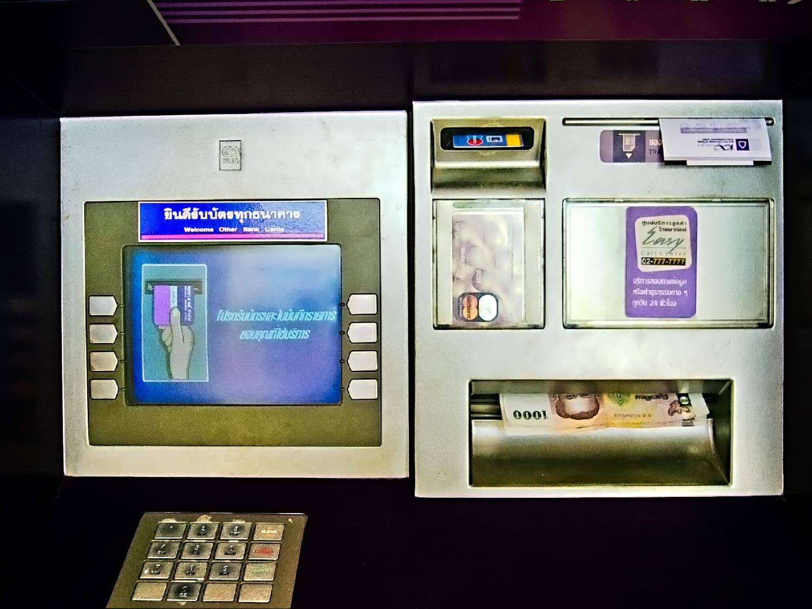 A Thai bank ATM dispensing 1000-baht notes