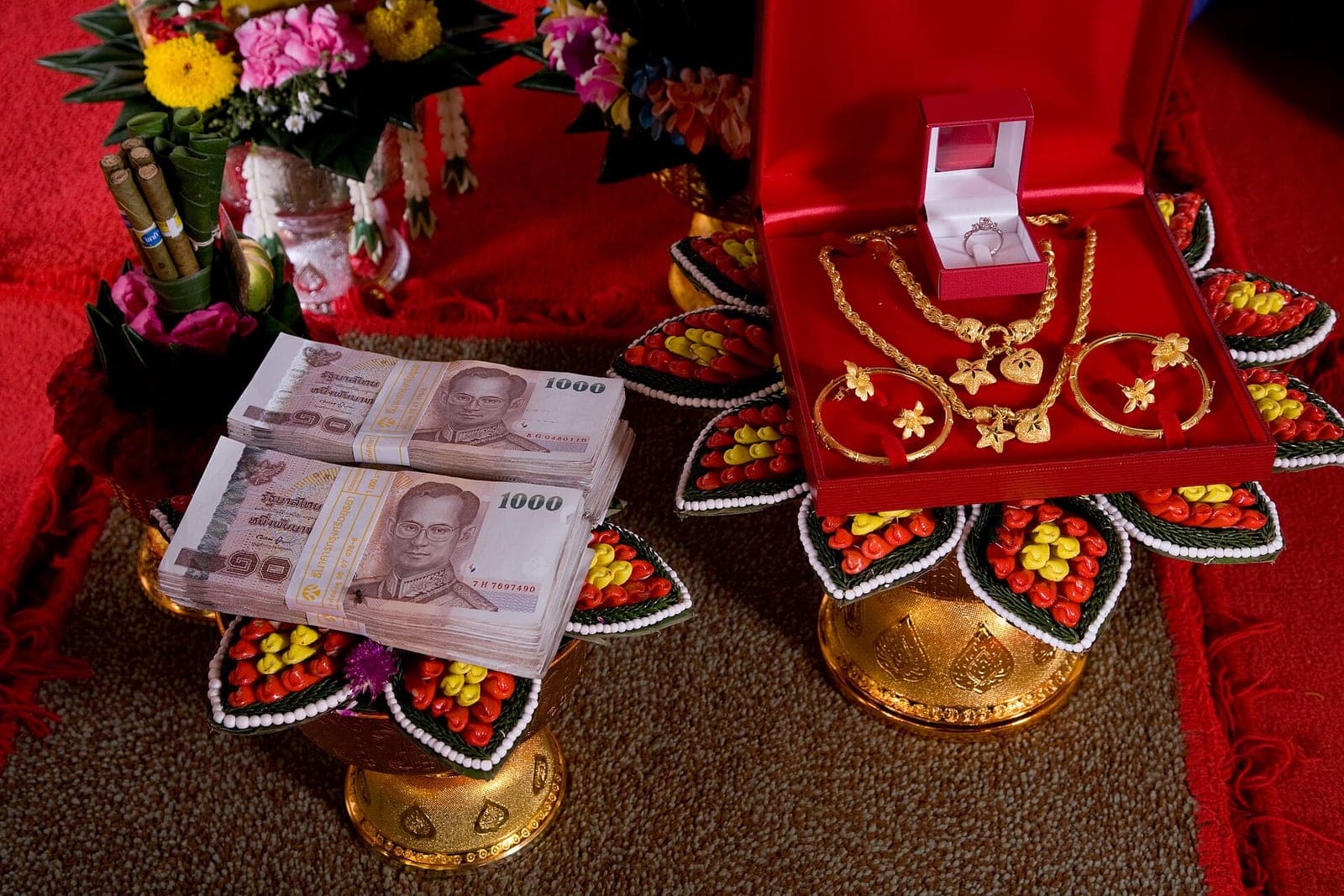 Stacks of 1000-baht notes and gold jewellery displayed on trays as a Thai bride price (sin sod)